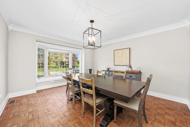 dining space featuring crown molding, a chandelier, and baseboards