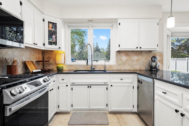 kitchen with appliances with stainless steel finishes, a sink, and white cabinetry