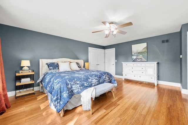 bedroom with light wood-style flooring, baseboards, a ceiling fan, and a closet