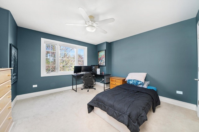 bedroom with light colored carpet, a desk, baseboards, and ceiling fan