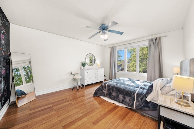 bedroom with light wood-style flooring, baseboards, and ceiling fan