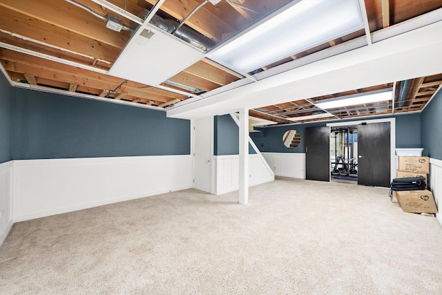 basement featuring carpet flooring and wainscoting