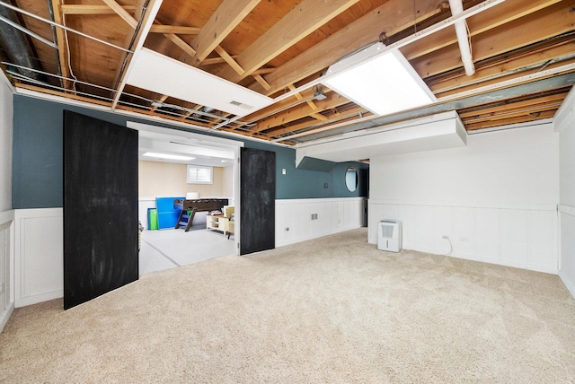 below grade area featuring wainscoting and carpet flooring