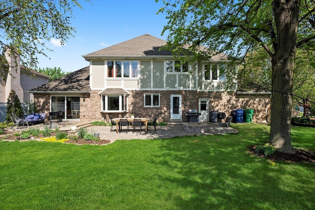 rear view of house featuring a patio area, a lawn, stucco siding, brick siding, and a fire pit