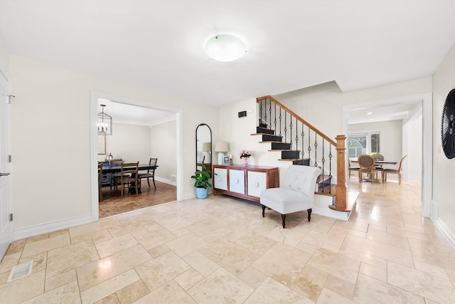 entryway with stairway, stone tile floors, baseboards, and a chandelier