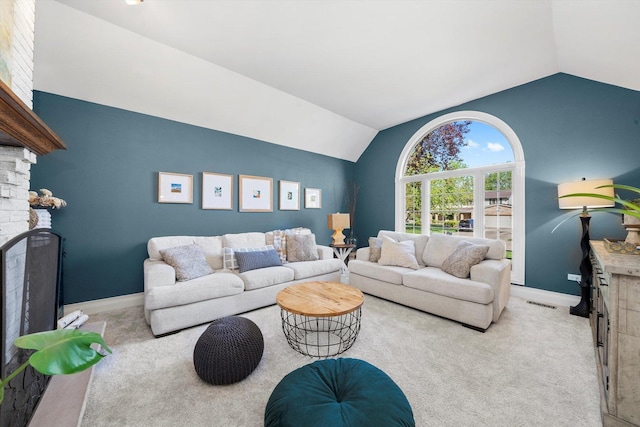 living area with a fireplace, lofted ceiling, baseboards, and carpet