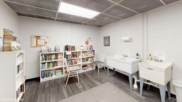 interior space with wood finished floors and concrete block wall
