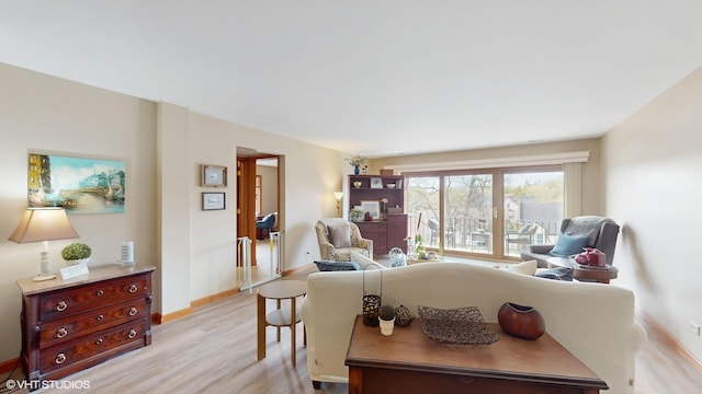 living area with light wood-style floors and baseboards