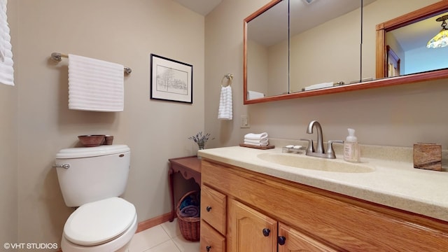 bathroom with vanity, baseboards, tile patterned floors, and toilet