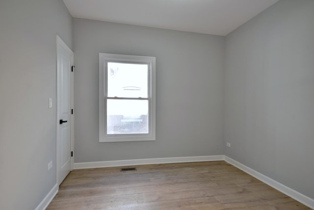 spare room featuring baseboards, visible vents, and light wood finished floors