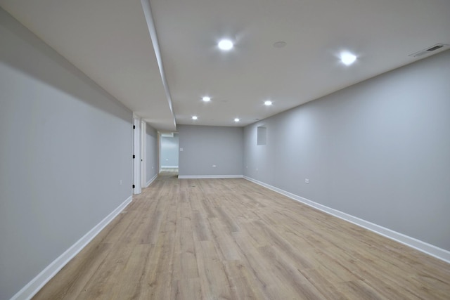 finished below grade area with recessed lighting, baseboards, light wood finished floors, and visible vents