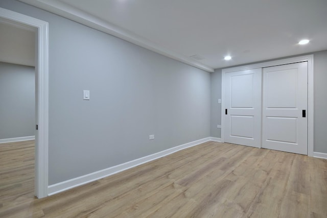 unfurnished bedroom with recessed lighting, baseboards, light wood finished floors, and a closet