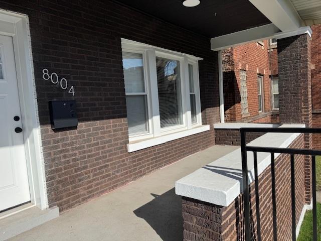 view of home's exterior featuring brick siding and covered porch