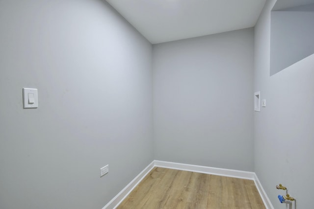 spare room with baseboards and light wood-type flooring