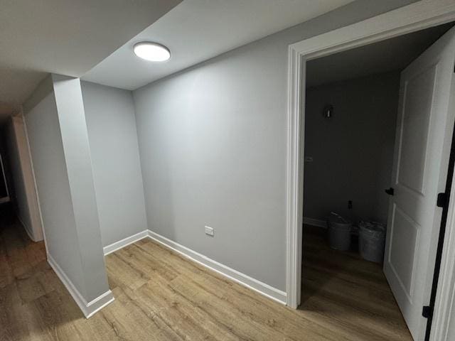 corridor featuring light wood-type flooring and baseboards
