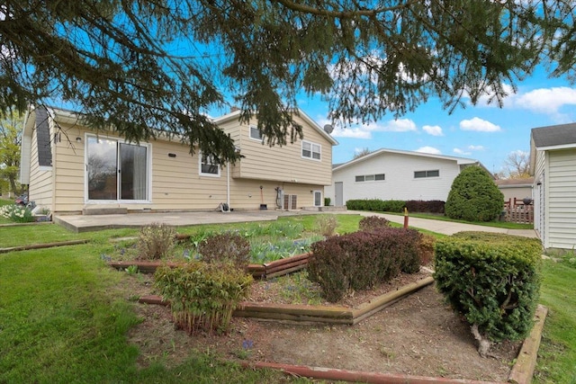back of property with a lawn and a patio
