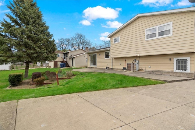 rear view of house with a lawn and a patio