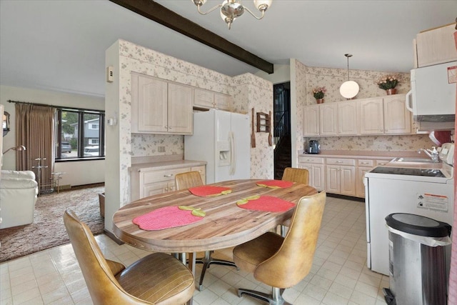 dining room with wallpapered walls, a chandelier, beamed ceiling, and washer / dryer