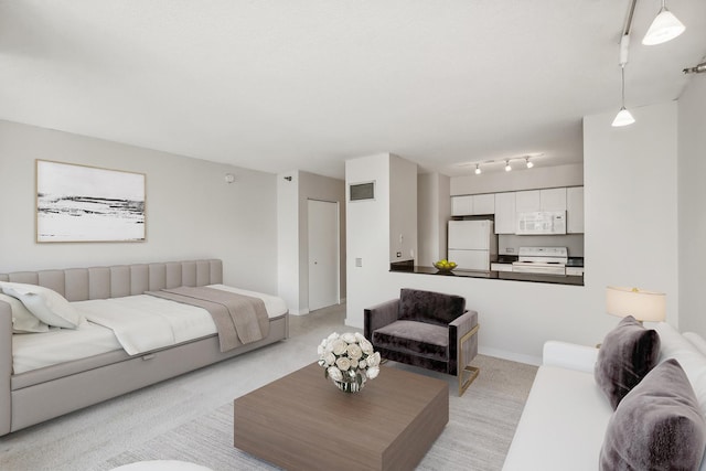 living area with track lighting, baseboards, visible vents, and light carpet