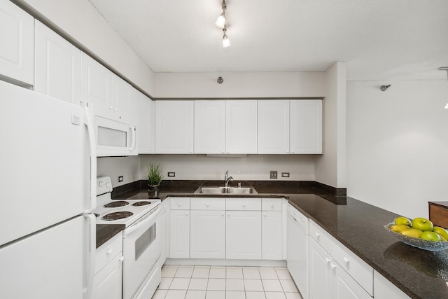 kitchen with white appliances, white cabinetry, and a sink