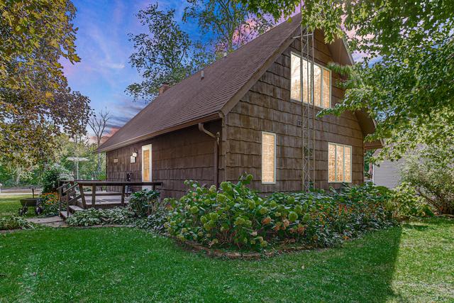 view of property exterior with a lawn, a shingled roof, and a wooden deck