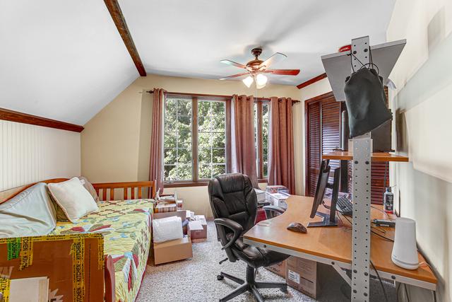 carpeted office with ceiling fan and lofted ceiling