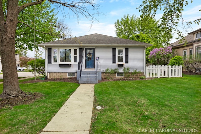 bungalow-style house with roof with shingles, fence, and a front yard