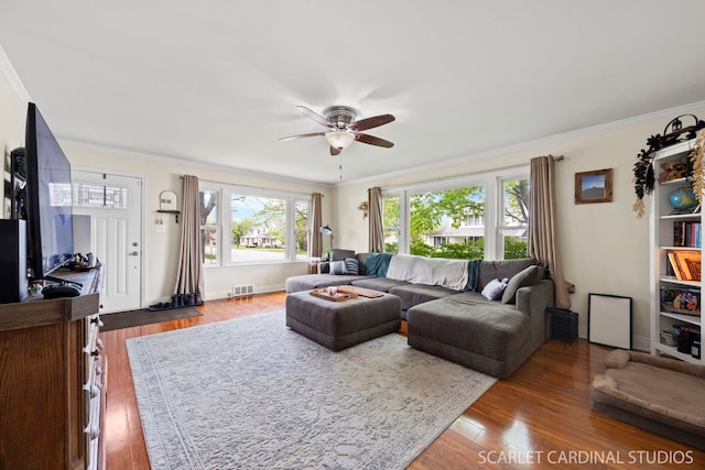 living room featuring visible vents, a ceiling fan, wood-type flooring, and ornamental molding