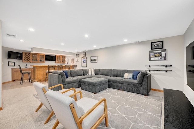 living area featuring wet bar, recessed lighting, baseboards, and light carpet