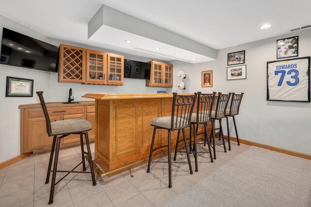 indoor wet bar featuring recessed lighting, baseboards, and light tile patterned flooring