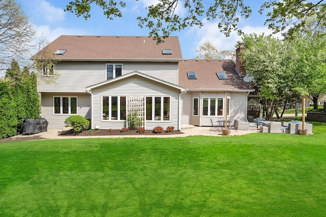 rear view of property featuring an outdoor hangout area, a chimney, a yard, and a patio area