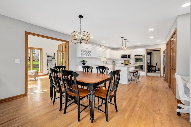 dining area featuring light wood finished floors, recessed lighting, a chandelier, and baseboards