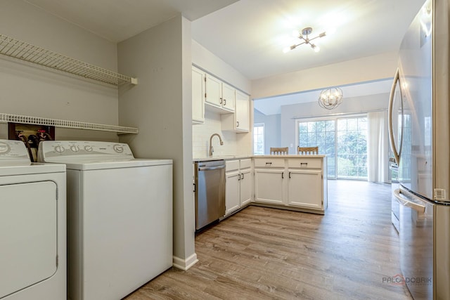 laundry area with a sink, separate washer and dryer, an inviting chandelier, and light wood finished floors