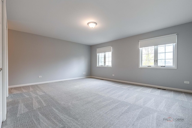 carpeted spare room with baseboards and visible vents