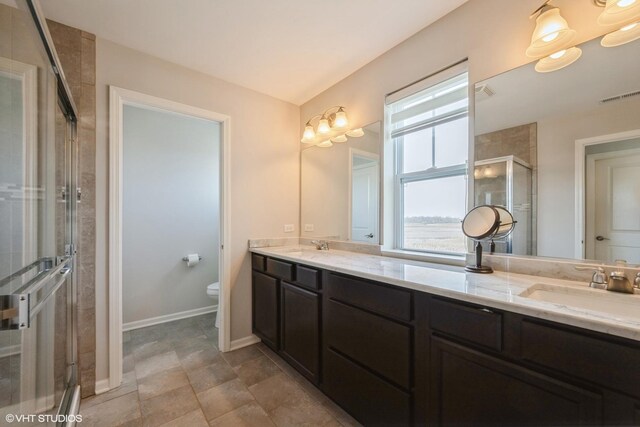 full bathroom with double vanity, visible vents, a shower stall, a sink, and toilet