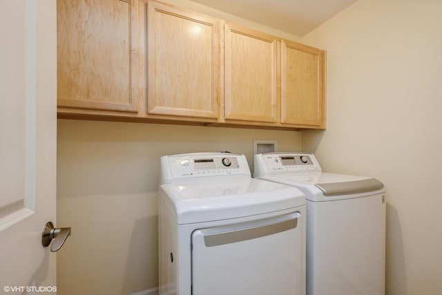 clothes washing area with washing machine and dryer and cabinet space