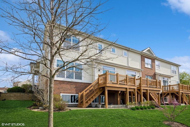 back of house featuring a wooden deck, stairs, a yard, and brick siding