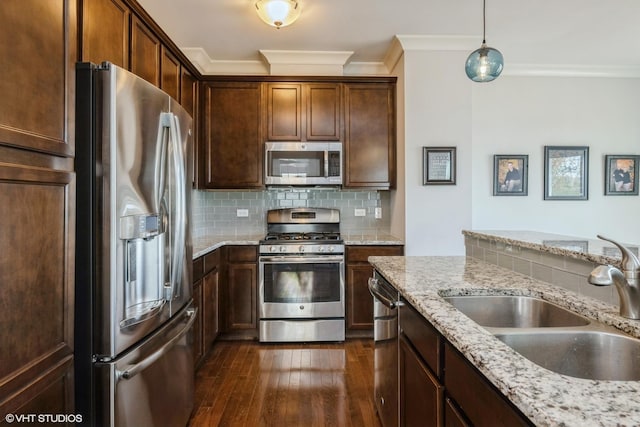 kitchen with appliances with stainless steel finishes, dark wood-style floors, a sink, tasteful backsplash, and ornamental molding