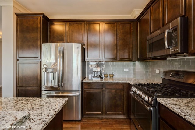 kitchen featuring dark brown cabinets, dark wood-style floors, light stone counters, backsplash, and stainless steel appliances