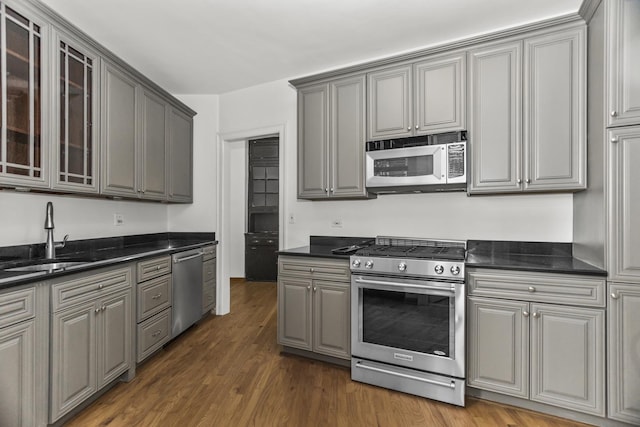 3300 N Lake Shore Dr Unit 12B, Chicago, IL 60657 - kitchen featuring appliances with stainless steel finishes, gray cabinets, a sink, dark wood-style flooring, and glass insert cabinets