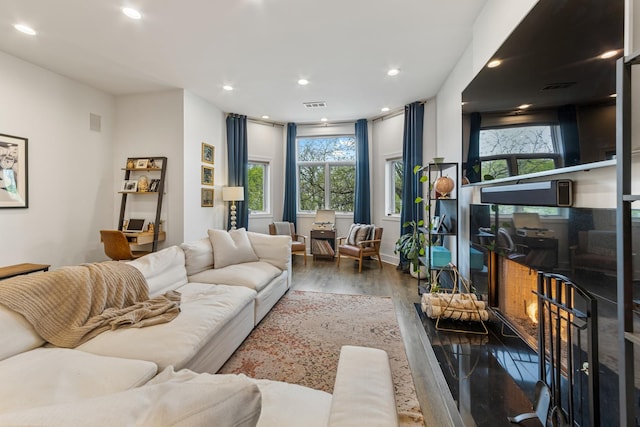 living room with visible vents, recessed lighting, and wood finished floors