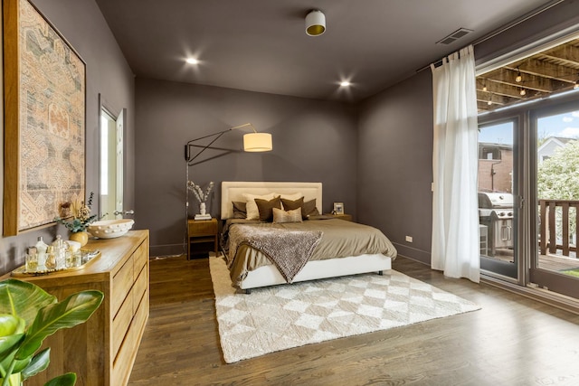 bedroom with visible vents, baseboards, dark wood-style floors, and access to exterior