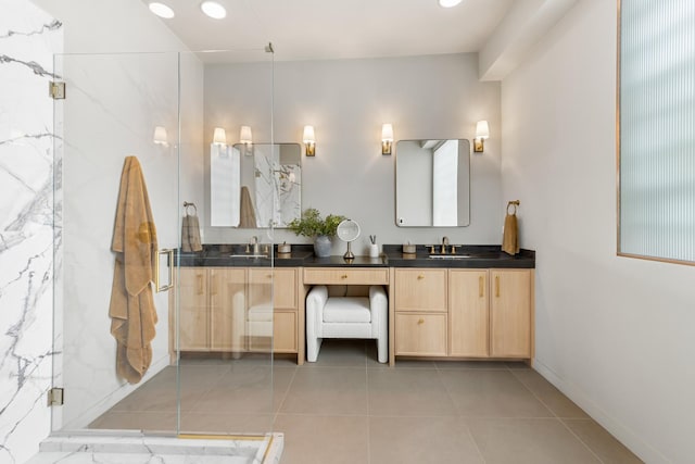 bathroom with double vanity, a sink, a marble finish shower, and tile patterned flooring