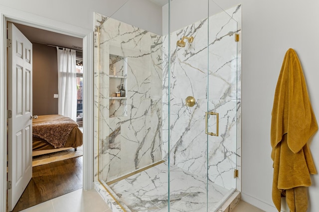 bathroom featuring connected bathroom and a marble finish shower