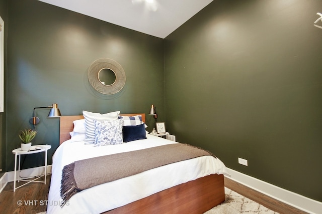 bedroom with baseboards and wood finished floors