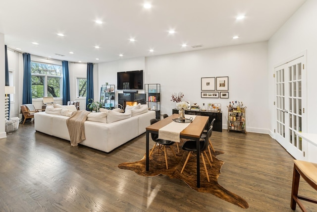 living room featuring recessed lighting, baseboards, dark wood-style flooring, and visible vents