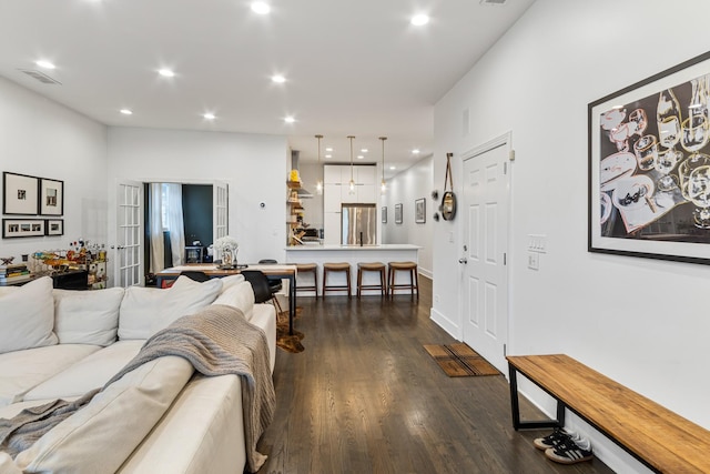 living room with recessed lighting, visible vents, and dark wood-style floors