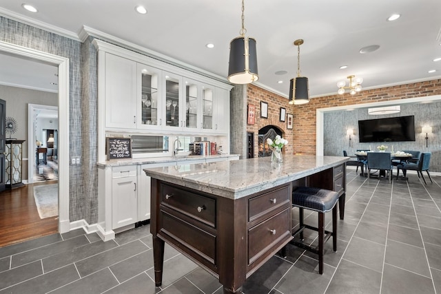 kitchen with dark tile patterned flooring, crown molding, white cabinetry, and dark brown cabinets