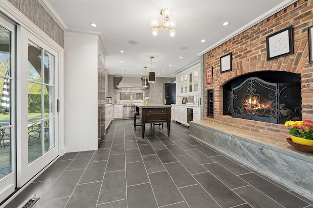dining space with dark tile patterned floors, recessed lighting, ornamental molding, and a fireplace