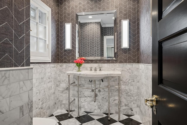 bathroom with crown molding, toilet, and tile walls